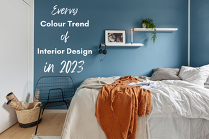 A simple room with one wall painted blue the other white. The title "Every colour trend of interior design in 2023" is on the blue wall