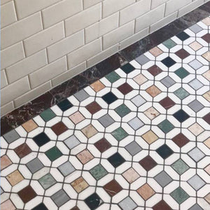 Installed Barcelona Marble Mosaic flooring with multicolour marble squares and white borders, set against cream subway wall tiles and a dark marble skirting.