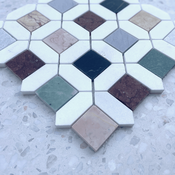 Angled view of Barcelona Marble Mosaic showcasing colorful marble squares and white geometric borders on a terrazzo surface.