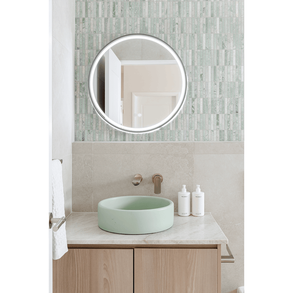Modern bathroom with Kit Kat Paradiso Green Finger Mosaic tiles as a feature wall behind a round mirror and mint basin.