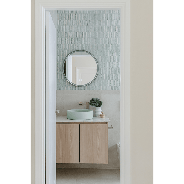 Minimalist bathroom with Kit Kat Paradiso Green Finger Mosaic feature wall, mint basin, and floating wood vanity.