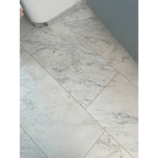 Greek Volakas Marble tiles in a bathroom setting, showing natural veining and a smooth matte finish.