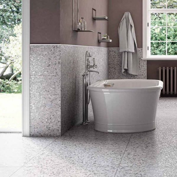 bathroom with grey terrazzo flooring. The walls are painted in dark purple and there is a white bathtub in the image.