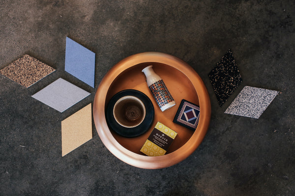 top angle image of tiles laid down with a bowl that contains some handicraft tools