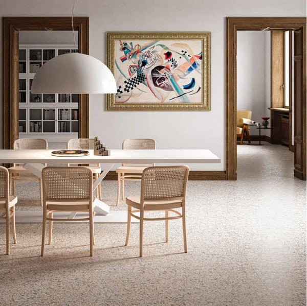 living room with white walls and terrazzo flooring. There is a painting hanging on the walls and the design incorporates the colour orange.