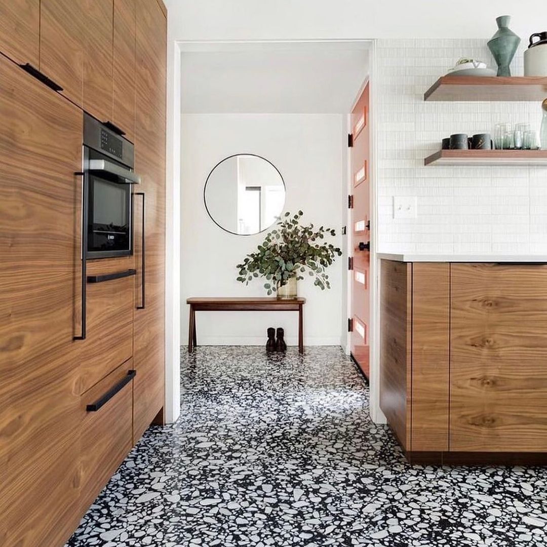 black and white patterned terrazzo flooring with timber-look cupboards kitchen
